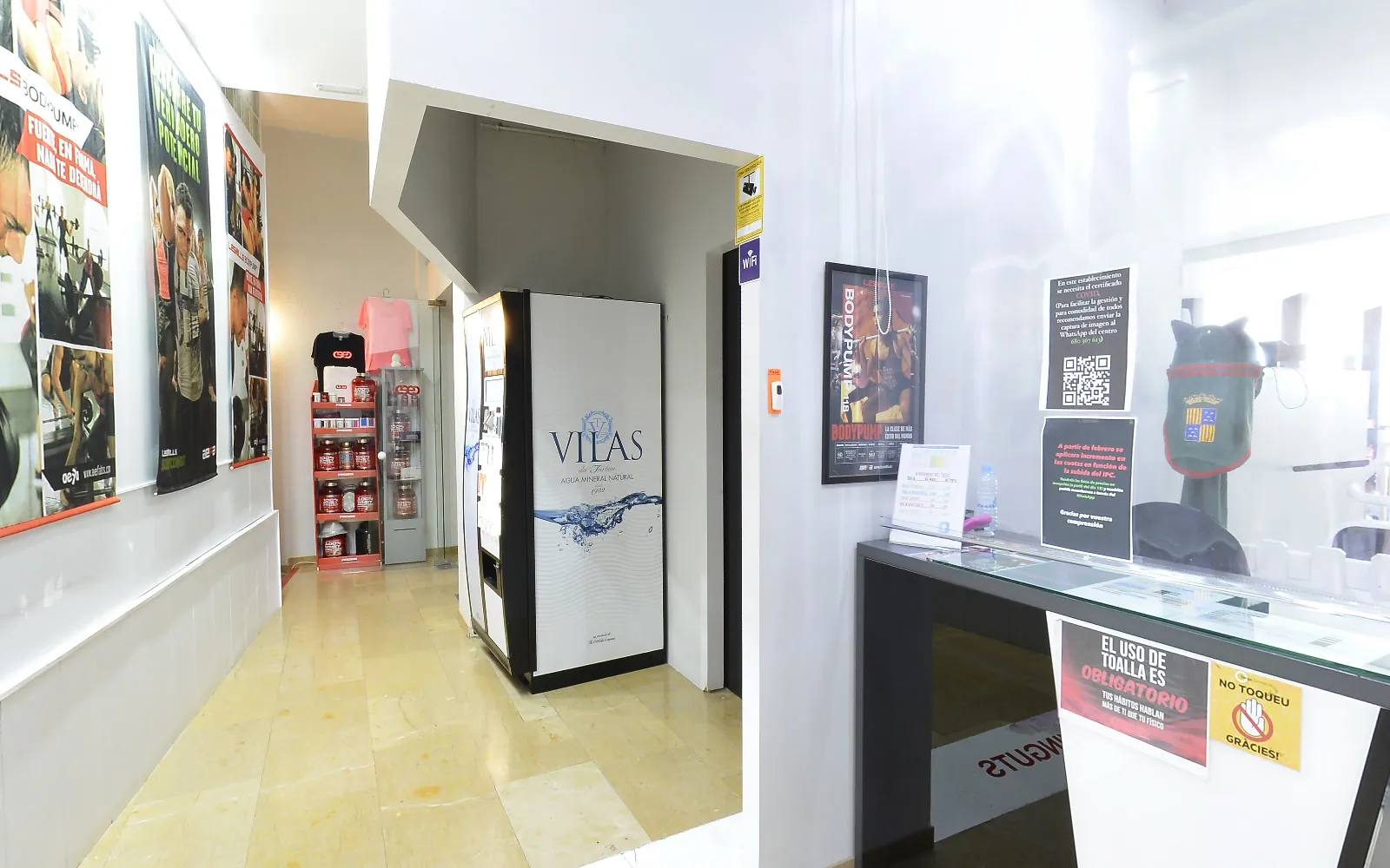 El passadís de la recepció, amb la màquina de begudes i els cartells
